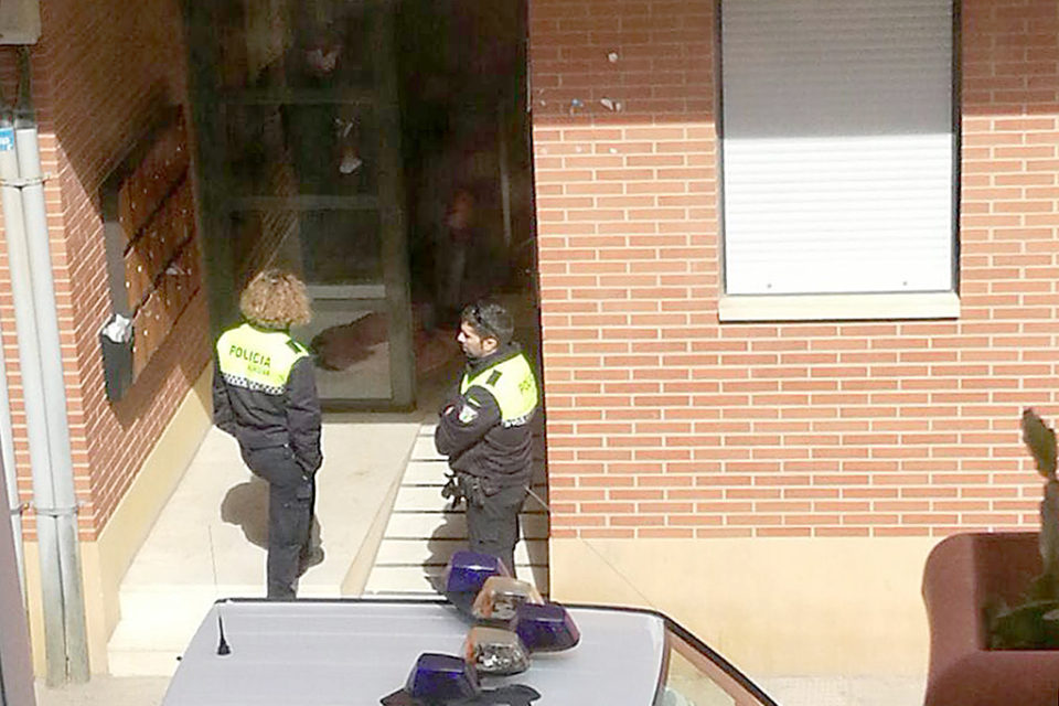 Dos agentes de policía aguardan en el portal del domicilio de la víctima. /NR