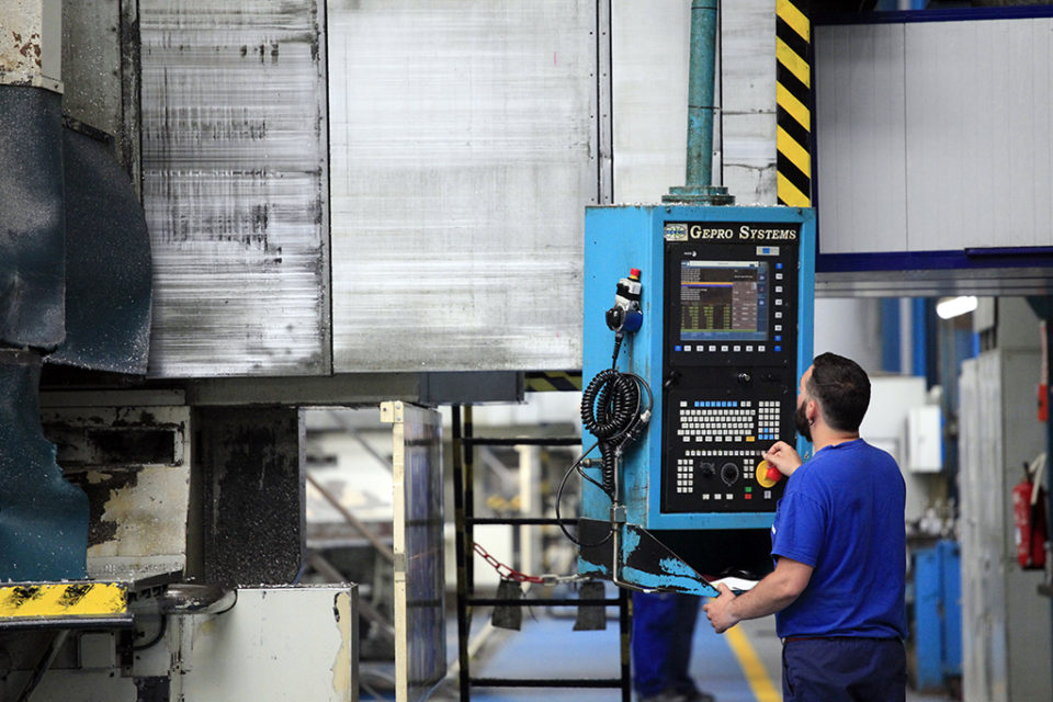Un trabajador manipula una máquina en una fábrica. / Ingrid