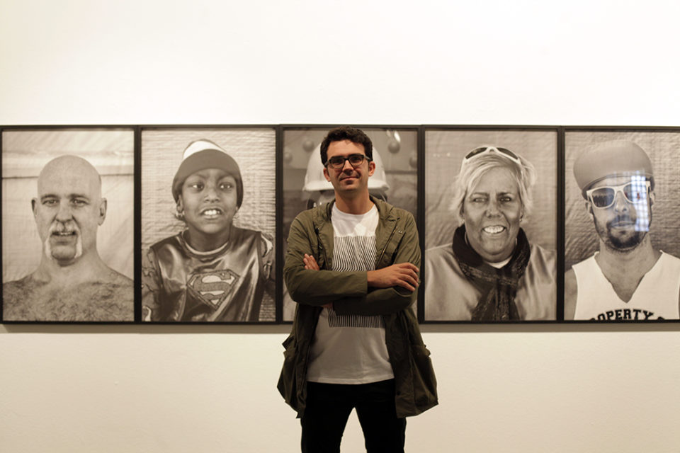 El autor de la exposición, junto a algunas de sus fotos expuestas. / Ingrid