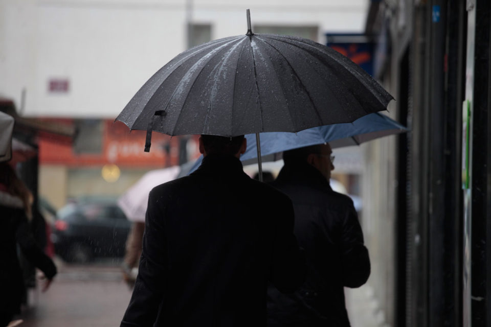 Viandantes se protegen bajo sus paraguas de la lluvia. / Clara Larrea