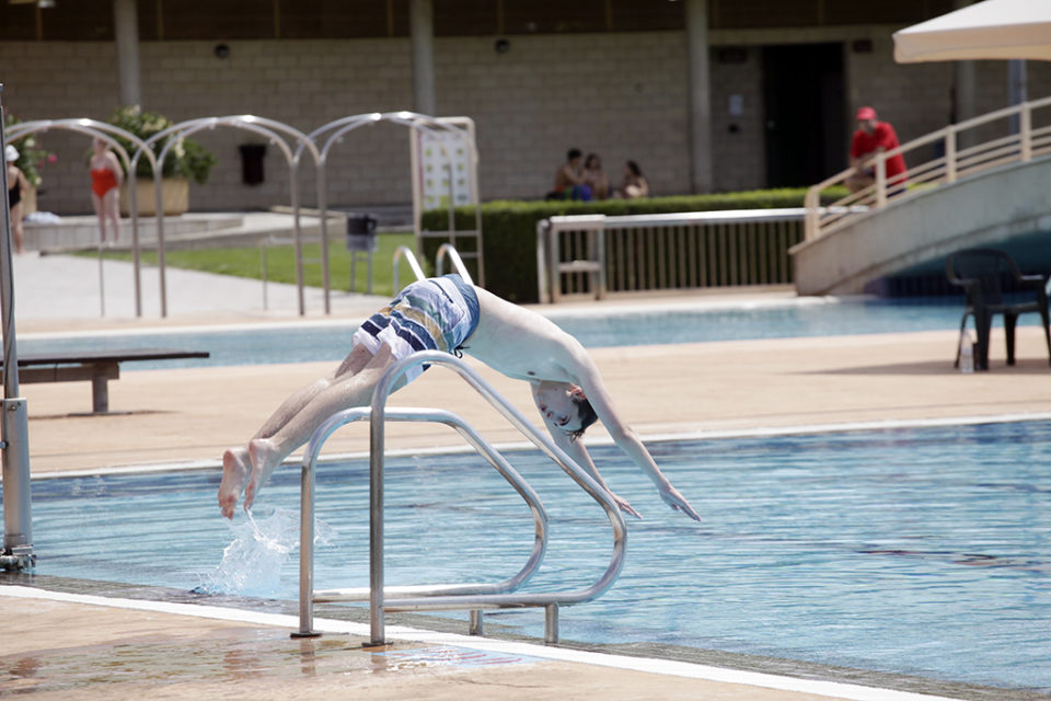 Un joven se lanza a la piscina para combatir el calor. / Ingrid