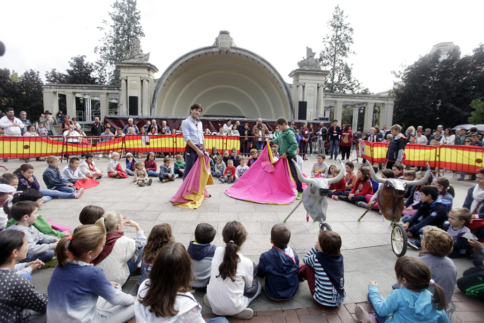 El torero José Garrido enseña a un niño a manejar el capote durante las fiestas de San Mateo 2016, una actividad que Cambia quiere suprimir. / Ingrid