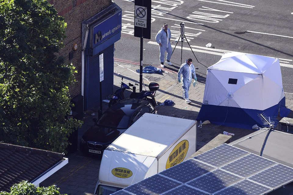 Dos policías forenses trabajan junto a la furgoneta, tras el ataque perpetrado cerca de la mezquita de Finsbury. / Facundo Arrizabalaga (Efe)