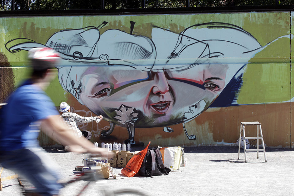 Uno de los artistas ultima el trabajo en la pasarela del parque del Ebro. / Ingrid