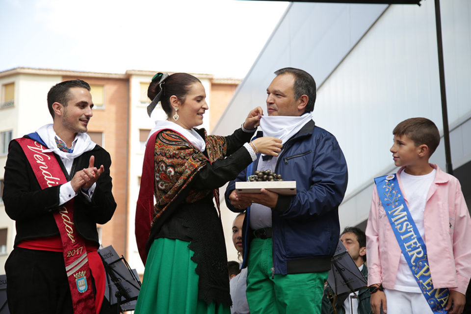Los vendimiadores colocan el pañuelo de la peña Áster al director del Grupo de Danzas de Logroño. / Clara Larrea