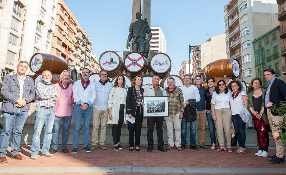 El sobrino del autor de la escultura, entre la alcaldesa y el exalcalde logroñeses, muestra una fotografía de la inauguración de la obra. / NR