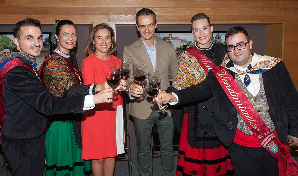 La alcaldesa y el concejal de Festejos, con los vendimiadores de este año (izquierda) y de las pasadas fiestas (derecha). / NR