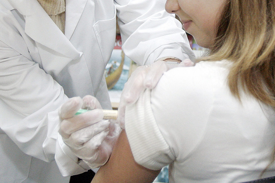 Una profesional sanitaria pone una vacuna a una niña. / Ingrid