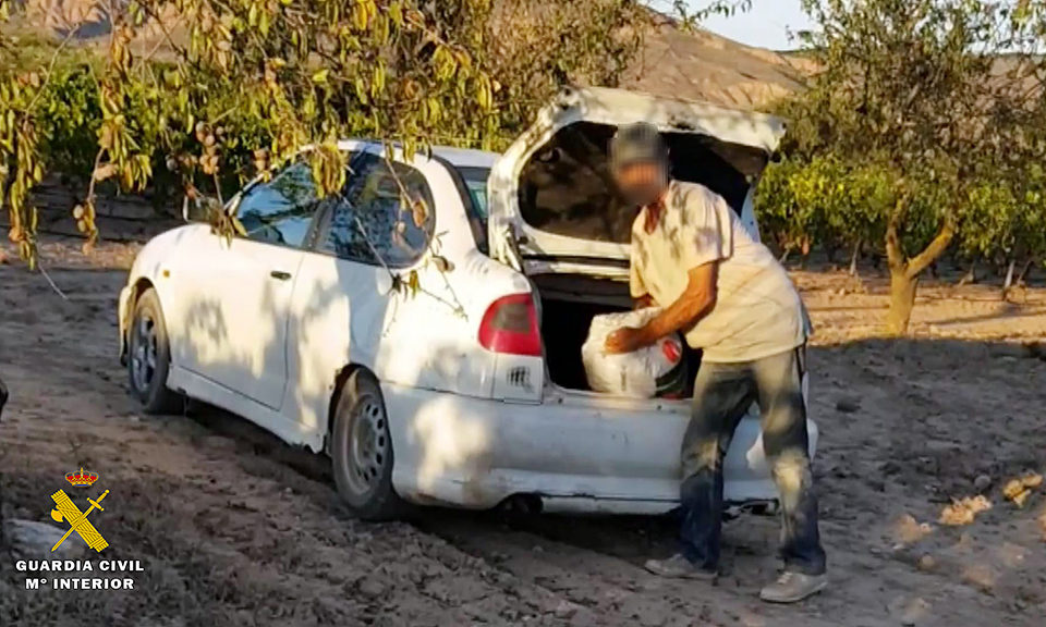 Uno de los detenidos, sorprendido por la Guardia Civil cuando cargaba un saco de almendras en el coche. / GUARDIA CIVIL