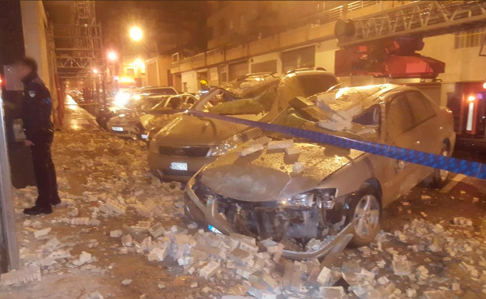 Daños provocados en los vehículos tras derrumbarse la fachada del edificio. / @bajominimosbomb (Twitter)