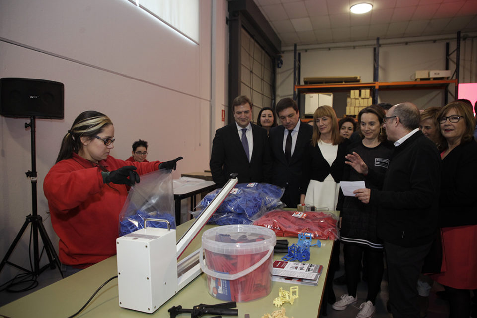 Una de las trabajadoras del centro de empleo de ASPACE muestra a las autoridades el trabajo que realiza. / Ingrid