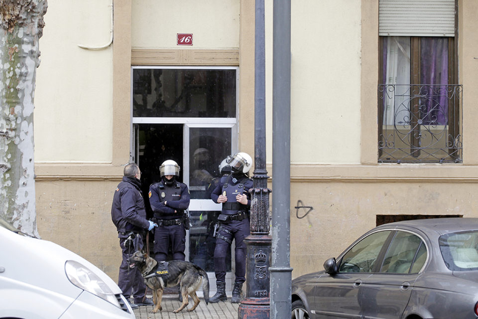 Varios agentes custodian la entrada al edificio de avenida de Navarra donde se realizó una redada en 2018. /Ingrid