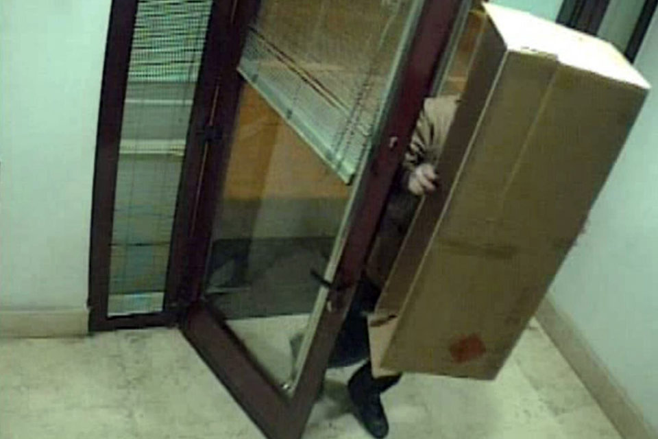 El ladrón entra la sucursal bancaria tapado con una caja de cartón. / Guardia Civil