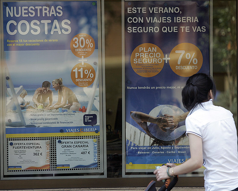 Una mujer observa las ofertas de una agencia de viajes. / Ingrid