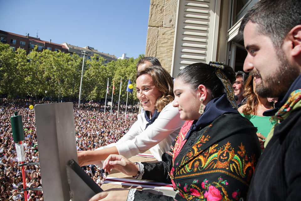 La alcaldesa encienda la mecha del cohete con los vendimiadores en el balcón del Ayuntamiento. / Clara Larrea