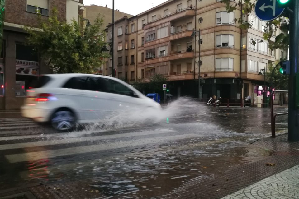 Un coche atraviesa una balsa de agua en la calle República Argentina. /INGRID