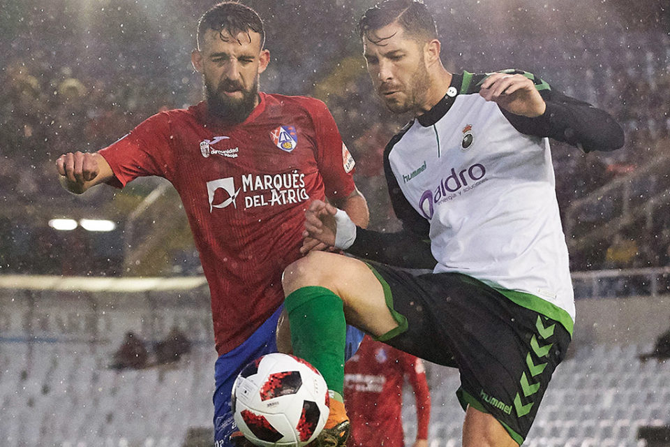 Parla disputa la pelota a un jugador racinguista, bajo el fuerte aguacero que cayó sobre El Sardinero. / CD Calahorra
