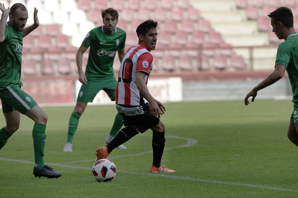 Rayco, rodeado de jugadores del Sporting B. El Arenas jugó también de verde y fue superior a una indolente UDL. / Ingrid