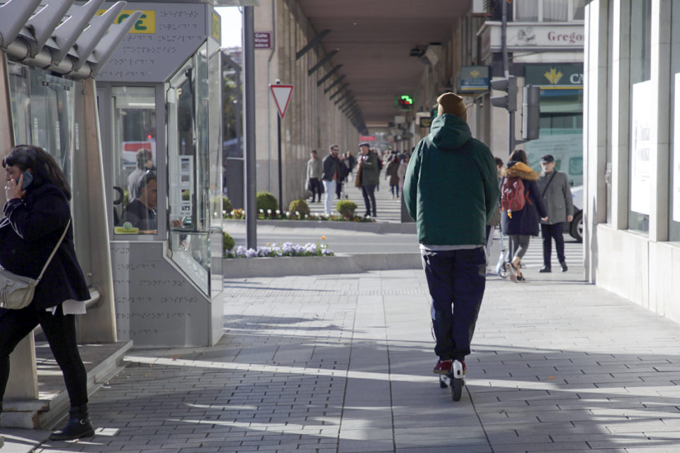 Un joven circula por una acera de Gran Vía con un patinete, en una imagen de archivo. / Darío Uruñuela