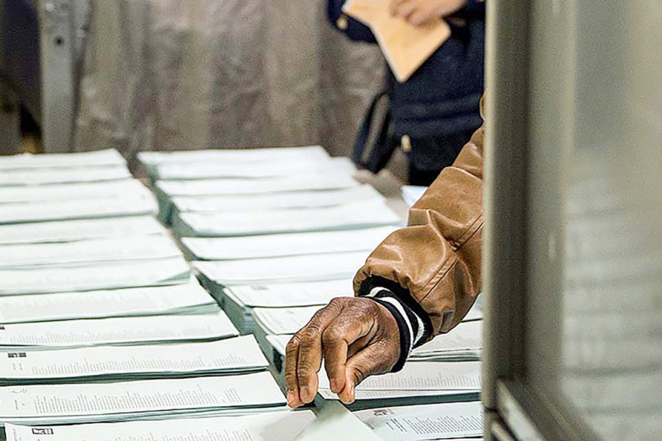 Un votante se dispone a coger una papeleta electoral este 26-M. / Raquel Manzanares (Efe)