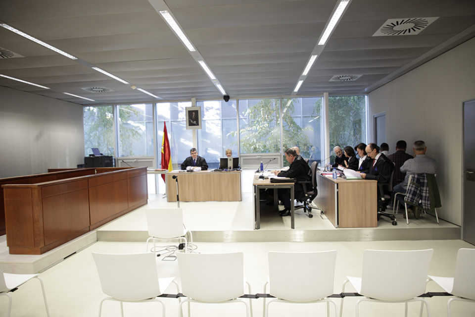 Los tres acusados, a la derecha de la imagen y de espaldas, en la primera sesión del juicio. / Ingrid