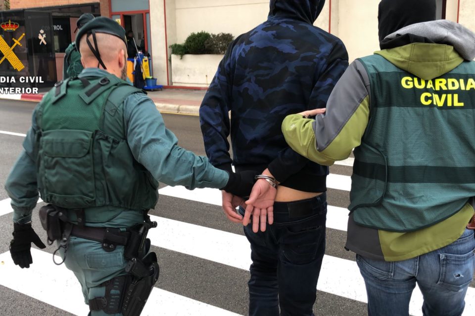 Dos guardias civiles trasladan a uno de los detenidos. / Guardia Civil