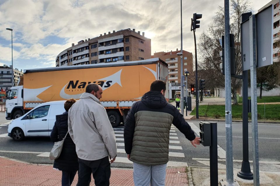 Los peatones accionan el pulsador del nuevo semáforo para poder cruzar el paso de cebra. / Ingrid