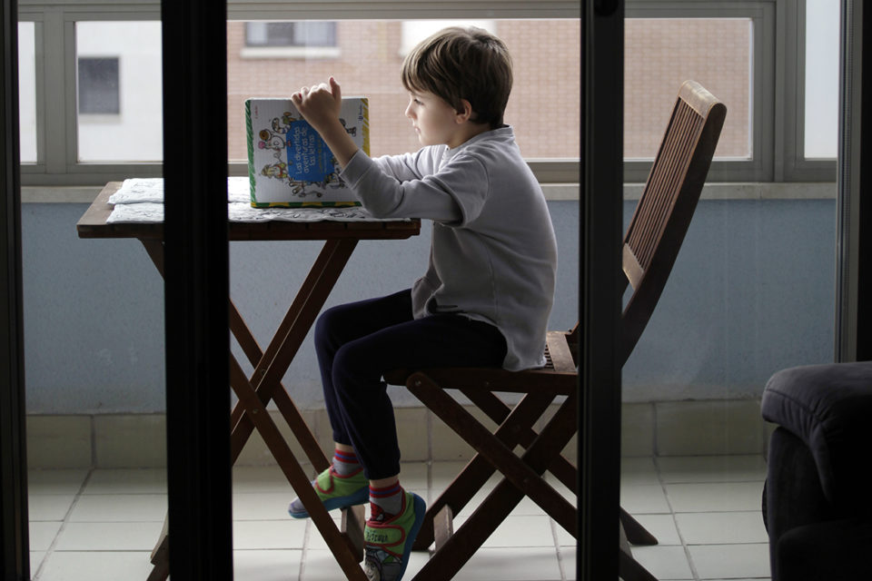 Un niño lee un libro en su casa de Logroño en pleno confinamiento. /INGRID
