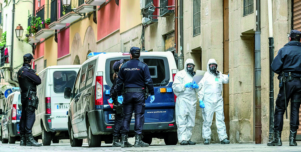Agentes de la Policía Nacional con trajes NRBQ se disponen a notificar a los vecinos de Marqués de San Nicolás de Logroño el aislamiento domiciliario. / Fernando Díaz (Efe)