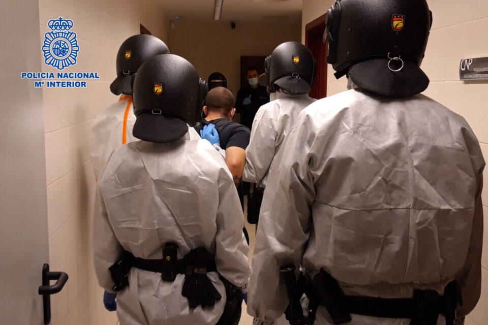 Los agentes se disponen a entrar en la vivienda protegidos con EPIs. / Policía Nacional